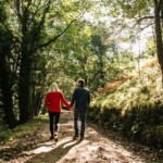 couple walking along wooded lane